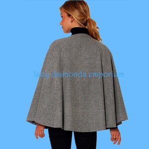 May include: A grey cape with a black turtleneck. The cape is made of a textured fabric and drapes over the shoulders. The text "lady diamonds emporium" is visible in the image.