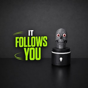 May include: A gray skull with prominent red and white eyes sits atop a black cylindrical base featuring a small white skull icon. To the left, the bright green text IT FOLLOWS YOU is displayed with curved lines above and below the word IT.