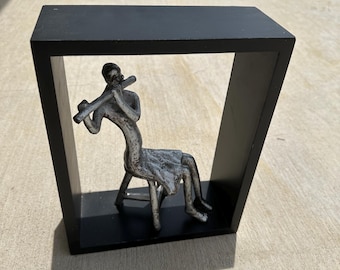 Uttermost Style Statue featuring a textured, cast aluminum musician playing a flute.