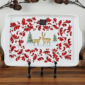 May include: White rectangular serving tray with a red and black floral design. The tray features a winter scene with two deer and evergreen trees. The tray has a black metal stand and the text "ITALY".