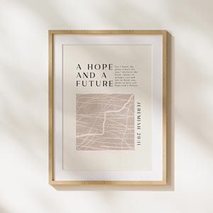 May include: A framed print with a beige background and a white abstract design. The text "A hope and a future" is printed in black at the top of the print. Below the design, the text "For I know the plans I have for you," declares the Lord, "plans to prosper you and not to harm you, plans to give you hope and a future." Jeremiah 29:11 is printed in black at the bottom right corner of the print.