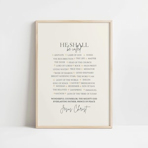 May include: A framed print with the words "He Shall Be Called" and a list of names for Jesus Christ. The text is in black and gold on a cream background, with a simple wooden frame. The print is a religious item.