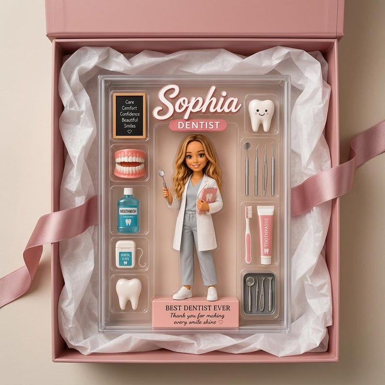 May include: A custom dentist figurine set in a clear display box inside a pink gift box. The set includes a doll named Sophia, a miniature chalkboard with text, a set of teeth, mouthwash, dental floss, a tooth icon, and various dental tools.
