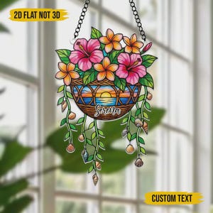 May include: A hanging floral basket decoration featuring pink hibiscus and orange flowers. The basket has a sunset scene and the name "Serena". The design includes hanging vines with seashells. Text at the top says "2D FLAT NOT 3D" and at the bottom "CUSTOM TEXT".