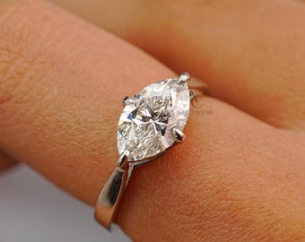 Puede incluir: Anillo de plata pulida con un diamante talla marquesa. El diamante está engastado con cuatro garras, resaltando su forma alargada y facetas. Una joya clásica.