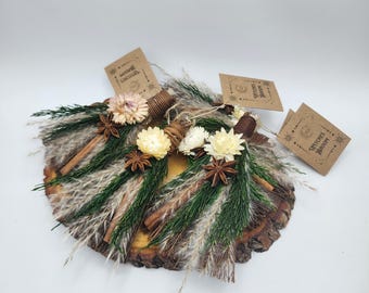 May include: Two decorative wooden slices adorned with natural elements. Each slice features dried flowers, cinnamon sticks, star anise, and greenery. Small tags with text are attached. The design has a rustic, natural aesthetic.