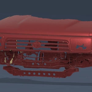 Pode incluir: Parte dianteira de um carro vermelho, incluindo o capô, a grelha e o para-choques. Os faróis estão em falta e existem algumas áreas danificadas. O veículo parece ser um camião ou SUV.