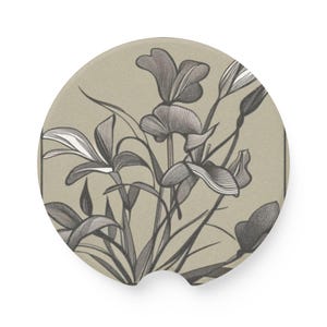 May include: A beige round coaster with a black and white floral design. The flowers are stylized and have a vintage look.