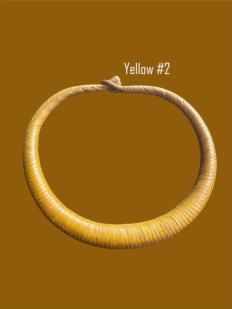May include: A yellow necklace with a textured, stitched design. The necklace is a circular shape with a knotted closure. The text "Yellow #2" is displayed in white.