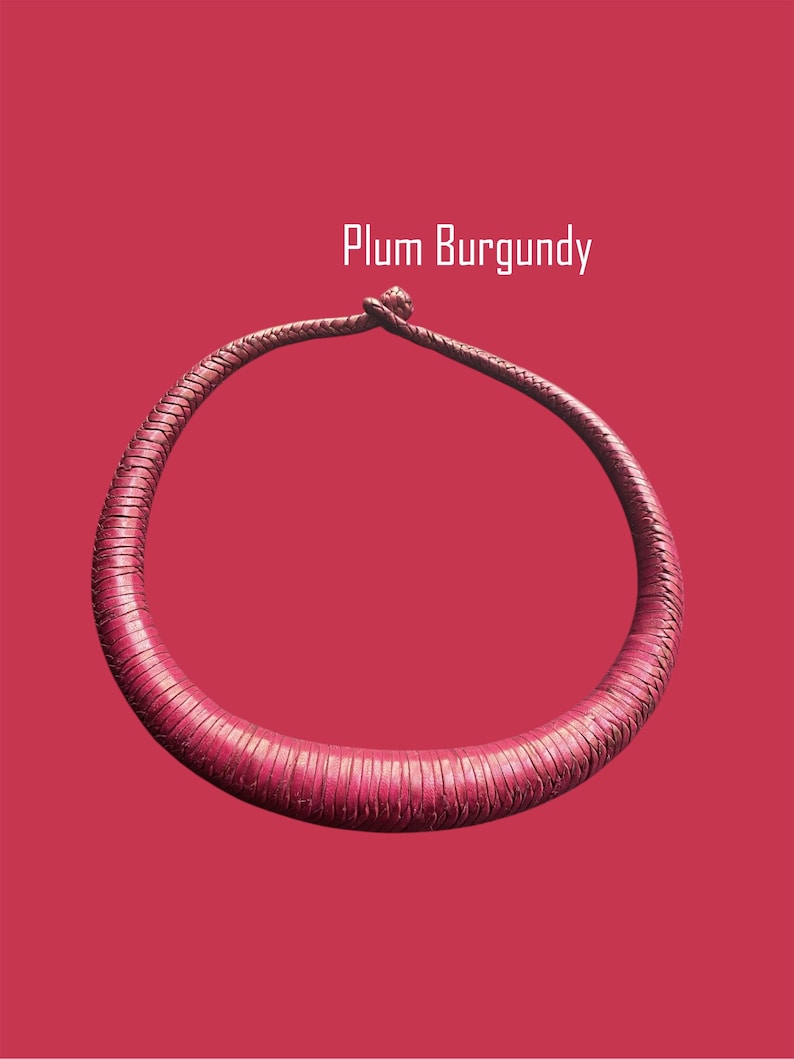 May include: A plum burgundy necklace with a textured, circular design. The necklace is set against a matching background, with the text "Plum Burgundy" in white.