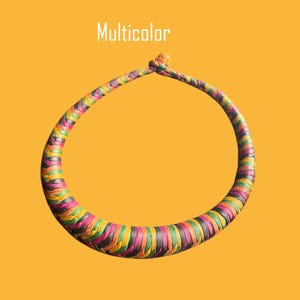 May include: A woven necklace in a circular shape, featuring a vibrant array of colors including pink, green, yellow, and black. The word "Multicolor" is displayed in white text above the necklace against a yellow background.