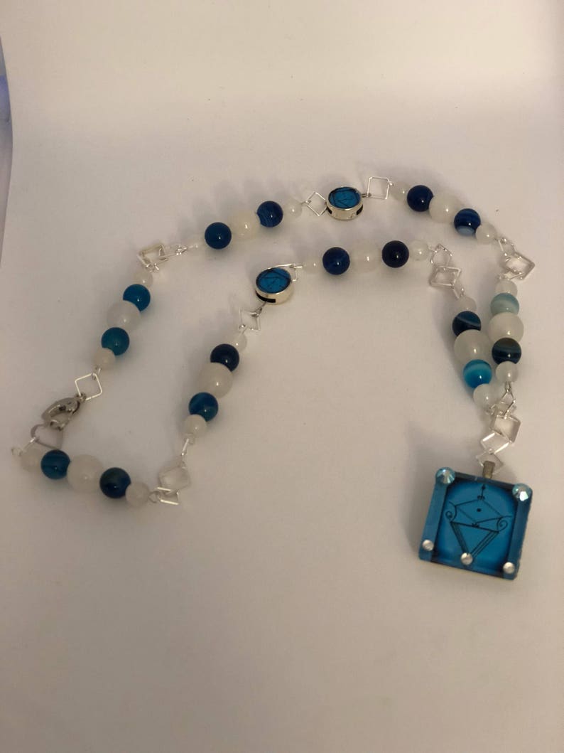 Two accent veve beads adornments. la Sirene Vodou Veve pendant with blue agate and moonstone beaded necklace