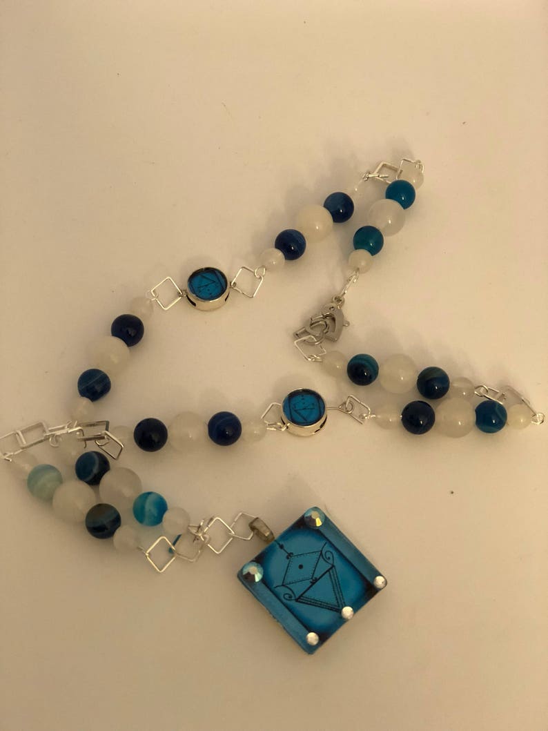 Two accent veve beads adornments. la Sirene Vodou Veve pendant with blue agate and moonstone beaded necklace