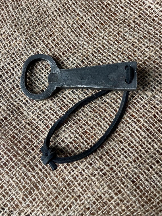 Hand-forged with real texture and a rugged rawhide loop — 11 favorites confirm this no-frills blacksmith piece earns its place on a keyring or bar.