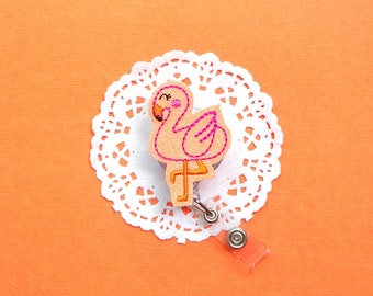 May include: A pink flamingo with a white lace doily and a retractable badge holder.