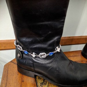 May include: Black leather boots with a silver and blue rhinestone ankle bracelet.