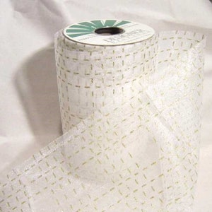 May include: A roll of white mesh ribbon with gold glitter accents. The ribbon has a checkered pattern.