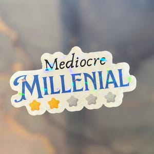 May include: A white sticker with a blue and iridescent design. The sticker says "Mediocre Millennial" with three gold stars below the text.