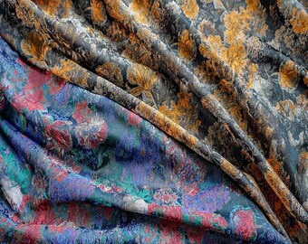 May include: Close-up of three sections of patterned fabric. The top section features a dark background with gold floral designs. The middle section has a dark background with a floral pattern in shades of gold and grey. The bottom section displays a floral pattern in shades of red, blue, and green.