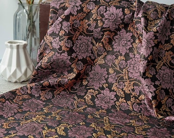 May include: A draped fabric with a floral pattern. The fabric features large, stylized flowers in shades of purple and gold against a black background. The design includes intricate details and a textured appearance, suitable for upholstery or decorative projects.