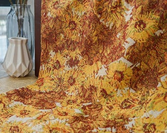 May include: A decorative textile featuring a sunflower pattern in shades of yellow, brown, and green. The fabric is draped, showcasing the intricate floral design. The textile is likely used for home decor, such as a tablecloth or throw.