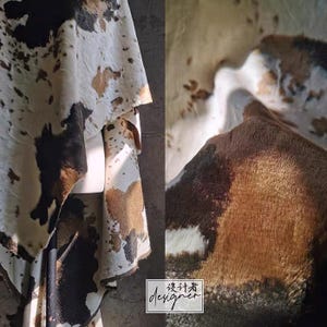 May include: Cowhide textile with a natural pattern of brown, black, and white spots. The material is draped, showcasing its texture and color variations. The image includes a close-up view of the hide's surface and a designer's logo.