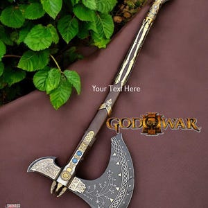 May include: A replica of the Leviathan Axe from the God of War video game. The axe has a black blade with gold accents and a brown wooden handle. The handle is decorated with intricate carvings and the axe head features the God of War logo.