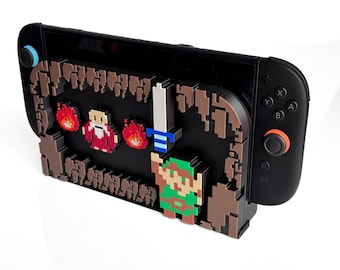 May include: Black Nintendo Switch console with a pixelated design featuring a green-clad character, a sword, flames, and a figure in red. The design is brown and black, with a blue and orange joystick.