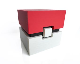 May include: A red, black, and white box with a square opening on the front. The box is made of plastic and has a smooth finish.