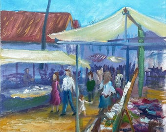 May include: An oil painting depicts a bustling outdoor market scene. Figures stroll beneath canvas awnings, with a red-roofed building in the background. The artwork uses a palette of blues, yellows, and reds to capture the lively atmosphere of the market.