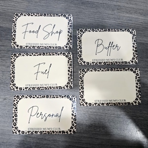 May include: Five rectangular labels with a leopard print border and a cream-colored centre. The labels read "Food Shop", "Fuel", "Personal", "Butter", and one blank label. The text "STRESSED MUM'S CLUB" is printed at the bottom of each label.