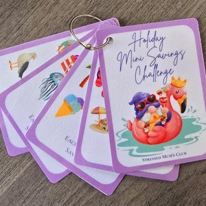 May include: Purple cards with a holiday mini savings challenge theme. The cards feature illustrations of a seagull, a seashell, an ice cream cone, a beach umbrella, and a gnome riding a pink flamingo. The text on the cards reads "Holiday Mini Savings Challenge" and "Stressed Mum's Club".