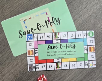May include: A board game called "Save-O-Poly" with a green background and colorful game board. The game board has spaces with prices in British pounds. A red die with white dots is next to the board.