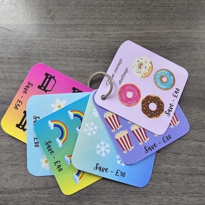 May include: Five colourful cards with different designs and the text "Save - £40", "Save - £50", "Save - £80", "Save - £90" and "Mini savings challenge".