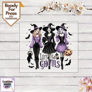 May include: A DTF transfer design featuring three figures in witch hats and dark clothing, accompanied by a black cat, a lantern, and a pumpkin. The text reads Let's Go Ghouls in purple and black lettering, surrounded by small black bat silhouettes.