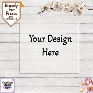 May include: A white wood background with a white rectangle in the center. The rectangle has the text "Your Design Here" in black. The top of the image has a yellow banner with the text "Ready For Press DTF Transfers". The bottom of the image has a purple banner with the text "Custom Magic DTF".