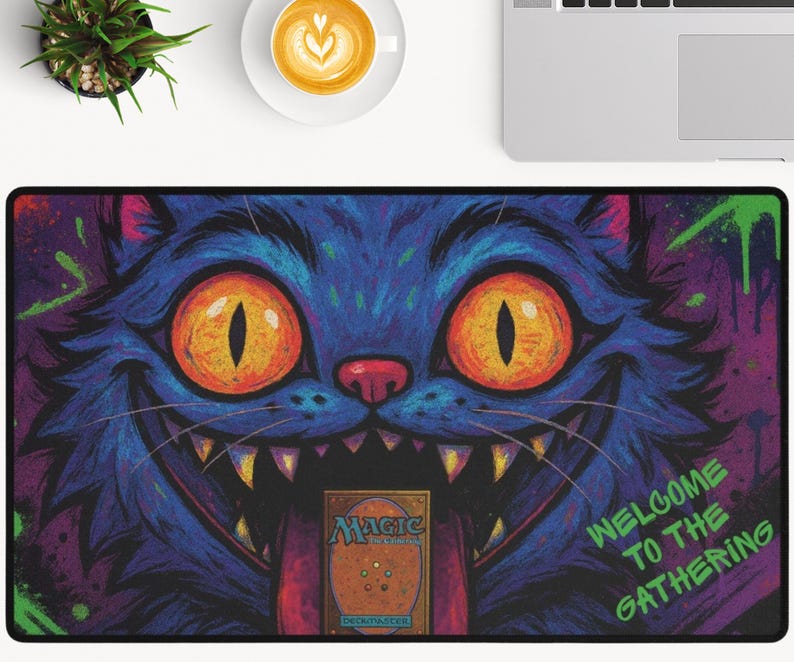K&ouml;nnte beinhalten: Rechteckige Schreibtischunterlage mit einem Cartoon-Katzen-Design. Die Katze ist &uuml;berwiegend blau mit orangefarbenen Augen und einem breiten Grinsen. Der Text "WELCOME TO THE GATHERING" ist sichtbar, mit einer Magic-Karte in der Mitte. Das Design hat rosa und lila Akzente.