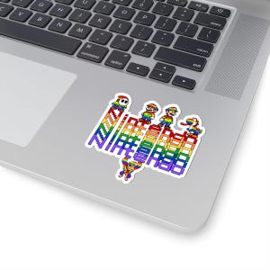May include: A sticker featuring pixelated characters and the word "NINTENDO" in rainbow colors. The characters include Mario, Shy Guy, and a dinosaur, all in vibrant colors, arranged on a rainbow-colored structure.