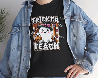 Könnte beinhalten: Schwarzes T-Shirt mit einem Halloween-Motiv. Das Design zeigt einen Cartoon-Geist mit Hexenhut und Kürbis, mit den Worten "TRICK OR TEACH" in einem dekorativen Rahmen. Das T-Shirt wird mit einer Jeansjacke getragen.