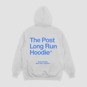 May include: White hoodie with a hood and long sleeves. The back of the hoodie features the text "The Post Long Run Hoodie" in blue, along with the phrases "Run Strong. Rest Well. Repeat."