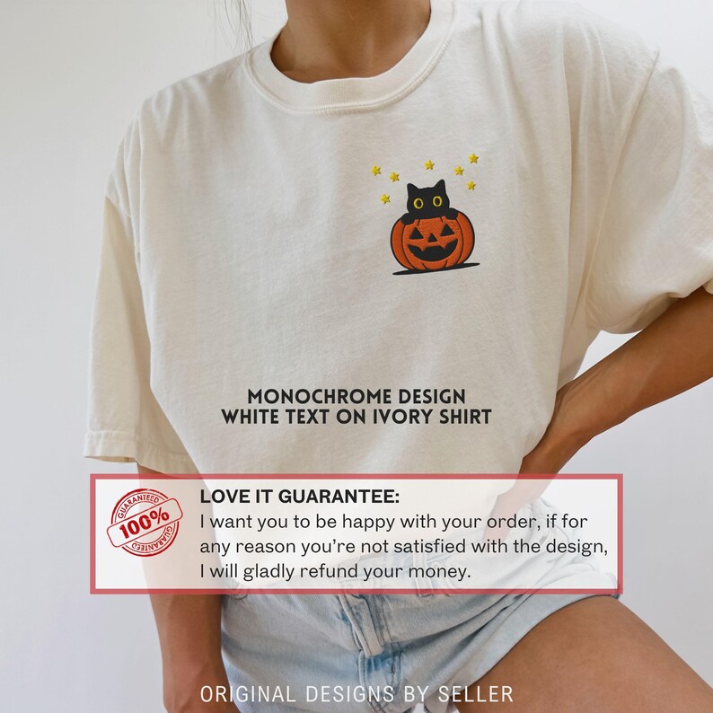 Może przedstawiać: Kremowa koszulka z czarnym kotem siedzącym na pomarańczowej dyni i ż&oacute;łtymi gwiazdami. Koszulka ma napis "MONOCHROME DESIGN WHITE TEXT ON IVORY SHIRT". Pokazana jest r&oacute;wnież gwarancja.