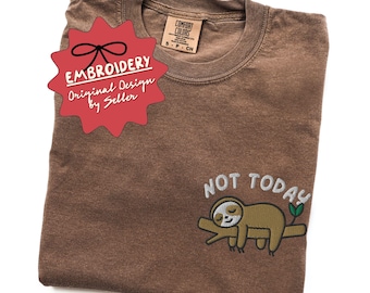 Puede incluir: Una camiseta marrón Comfort Colors con un diseño de perezoso bordado y las palabras "NOT TODAY". La camiseta también presenta una etiqueta roja que dice "EMBROIDERY Original Design by Seller."
