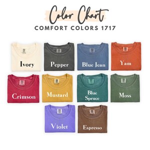 May include: A color chart displays nine t-shirts in various colors, including ivory, pepper, blue jean, yam, crimson, mustard, blue spruce, moss, violet, and espresso. The text "Color Chart" and "Comfort Colors 1717" are at the top.