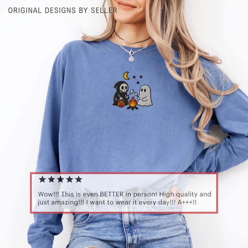 May include: A blue long-sleeve shirt with an embroidered Halloween design. The design features a Grim Reaper, a ghost, a campfire, a moon, and stars. The shirt also has the text "ORIGINAL DESIGNS BY SELLER" and a customer review.