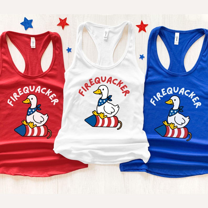 May include: Three tank tops in red, white, and blue, each featuring a cartoon duck wearing a bandana and sitting on a firecracker. The word "FIREQUACKER" is arched above the duck in red lettering. Patriotic themed apparel.
