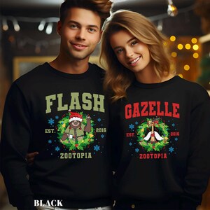 Op de afbeelding: Zwarte sweatshirts met feestelijke ontwerpen. E&eacute;n heeft het woord "FLASH" boven een luiaard met een kerstmuts, de andere heeft "GAZELLE" boven een gazelle. Beide hebben "ZOOTOPIA" en "2016" erop gedrukt.