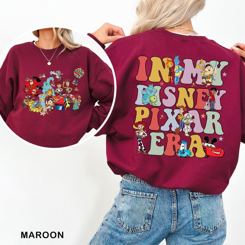 May include: Maroon sweatshirt featuring a colorful graphic of Disney and Pixar characters on the front and back. The back of the sweatshirt has the text "IN MY DISNEY PIXAR ERA" in a retro font. The front has a collage of characters.
