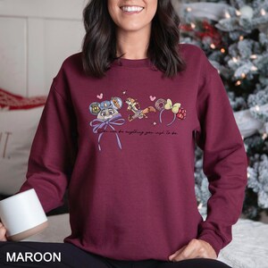 Puede incluir: Sudadera granate con un dise&ntilde;o de personajes de dibujos animados y el texto "You can be anything you wish to be." El dise&ntilde;o incluye un rat&oacute;n con gorra de polic&iacute;a, un zorro y un par de orejas.