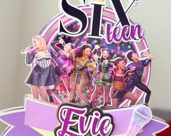 Puede incluir: Un adorno para tarta con el tema Six the Musical, con la palabra "Six" en negro y una corona, y "teen" en purpurina morada. El adorno presenta imágenes del elenco, una pancarta con el nombre "Evie" y un micrófono.