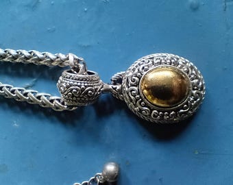 Vintage 16 1/2 to 19 inch long chunky silver tone necklace with pendant that has brass colored center